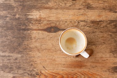 Boş beyaz kahve bardağını ahşap masada içtikten sonra kapatıyoruz..