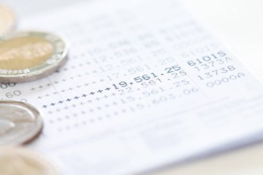 Tayland sikkelerinin seçici odak noktası beyaz arkaplan üzerine banka hesap beyanı üzerine yığılmış, kopyalama alanı ile yatırım konsepti için para toplamak.