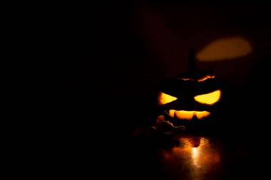 Cadılar Bayramı balkabağı kafalı Jack feneri koyu arkaplanda.