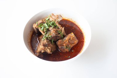 Baharatlı çorbada domuz kemiği, matarada beyaz masada servis edilir..