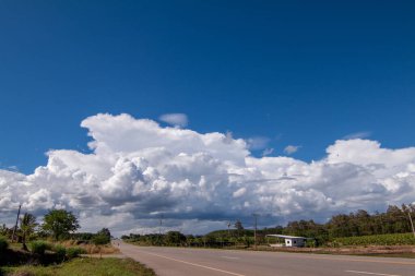 Tarım arazisi arka planına yağmur yağmadan önce gün boyunca beyaz bulutlu mavi gökyüzü..