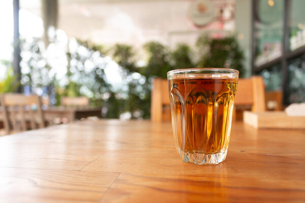 A cup of hot tea on wooden desk.