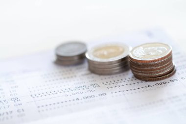 Tayland sikkelerinin seçici odak noktası beyaz arkaplan üzerine banka hesap beyanı üzerine yığılmış, kopyalama alanı ile yatırım konsepti için para toplamak.