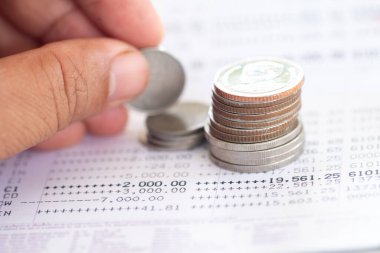 Tayland sikkelerinin seçici odak noktası beyaz arkaplan üzerine banka hesap beyanı üzerine yığılmış, kopyalama alanı ile yatırım konsepti için para toplamak.