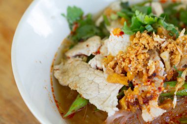 Baharatlı erişte çorbası, domuz eti, sebze ve ahşap masada servis edilen domuz eti..