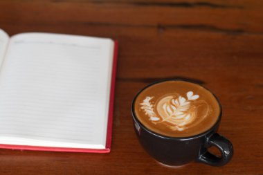 Tahta masada bir fincan Piccolo Latte sanatı, dinlenme zamanı ya da iş günü kahve molası..