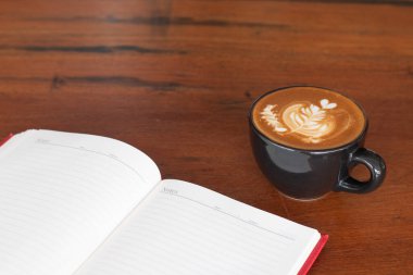 Tahta masada bir fincan Piccolo Latte sanatı, dinlenme zamanı ya da iş günü kahve molası..