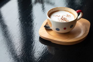 Tahta masada bir fincan Latte kahve, dinlenme zamanı ya da iş günü kahve molası..