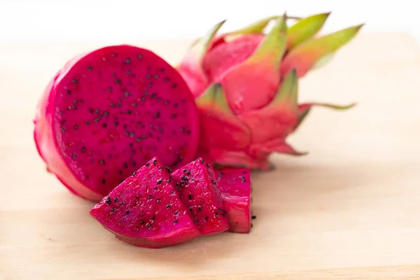 Taze pitahaya meyvesi dilimlenmiş ahşap arka planda veya olgun ejderha meyvesi kırmızı renkli içecek paketi tasarımı için fotokopi alanı tasarımı, sağlıklı makale resmi ve çiftlik kitabı tasarımı.