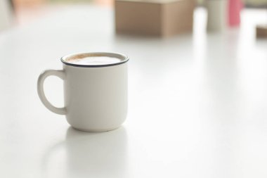 Eski bir fincan sıcak kahveyi beyaz şarap masasına, sütlü kahveyi kapat..