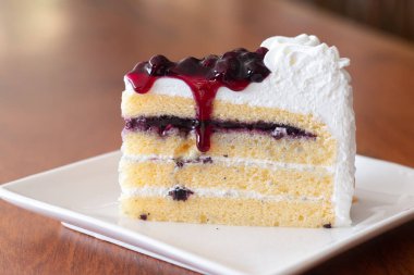 Beyaz tabakta böğürtlenli pasta dilimleri.