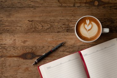 Üst görünüm defterli kalem ve iş geçmişi için bir fincan kahve..