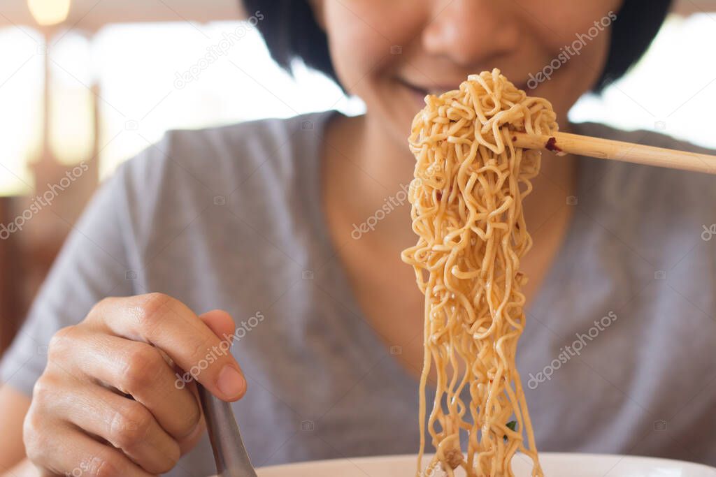 Young Asian woman is eating noodles, A Woman is having breakfast.