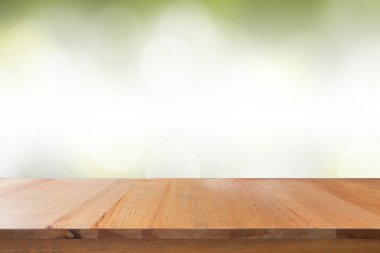 Bulanık yeşil gradyan bokeh soyut arkaplanı olan boş bir masa.