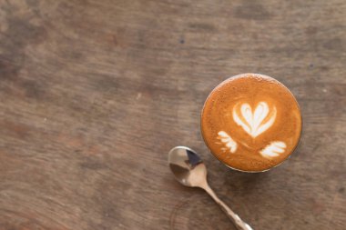 Pikolo Latte sanatı ahşap masadaki küçük bardakta..