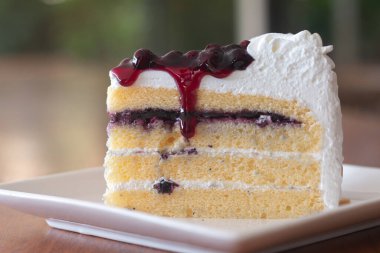 Beyaz tabakta böğürtlenli pasta dilimleri.