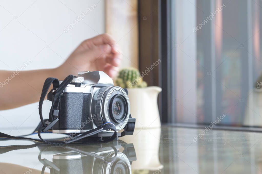 Digital camera on glass table in coffee shop.