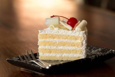 Beyaz peynirle kaplanmış, vanilyalı ve vişneli pasta..