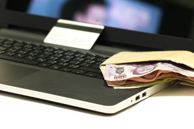 İnternetten alışveriş yaptıktan sonra kredi kartı, Tayland 500 Baht para birimi ve dizüstü bilgisayar, E-ticaret ağı pazarlama kavramı bulanıklığı.