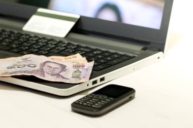 İnternetten alışveriş yaptıktan sonra kredi kartı, Tayland 500 Baht para birimi ve dizüstü bilgisayar, E-ticaret ağı pazarlama kavramı bulanıklığı.