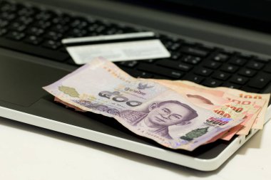 İnternetten alışveriş yaptıktan sonra kredi kartı, Tayland 500 Baht para birimi ve dizüstü bilgisayar, E-ticaret ağı pazarlama kavramı bulanıklığı.