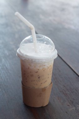 Bir bardak soğuk buzlu kahve ahşap masaya konur..