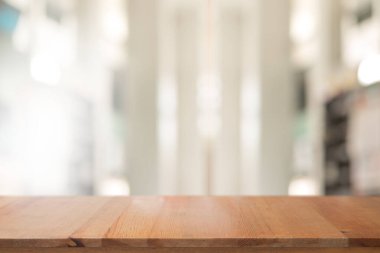 Ahşap masa, arka plan için soyut bulanık oturma odası dekorasyonuna sahip.