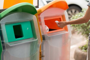 Kadın çöp kutusuna kağıt atıyor..