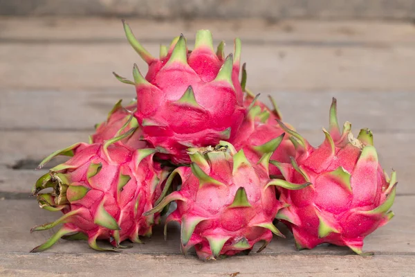 Red Dragon fruit or Tropical fruit on wooden desk background.