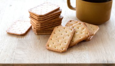 Tahta masada sıcak kahveyle servis edilen sütlü kraker, mola..