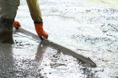 İnşaat işçisi beton döşeme döşüyor, inşaat işçileri ile inşaat, ev inşa konsepti..