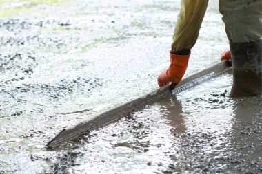 İnşaat işçisi beton döşeme döşüyor, inşaat işçileri ile inşaat, ev inşa konsepti..