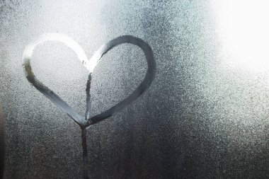 Sevgililer Günü geçmişi ya da düğün geçmişi için su damlası konsepti tasarımı içeren cam pencere üzerindeki kalp şekli.