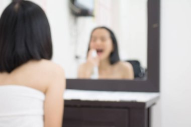 Bulanık bir kadın makyaj masasına yüz kremi sürüyor, güzellik arka planı kavramı..