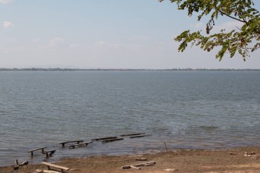 Gün boyunca mavi gökyüzü arkaplanlı göl manzarası.