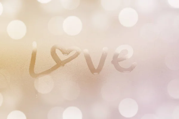 Closeup of LOVE word on glass window with water drop concept design for valentine\'s day or wedding background.