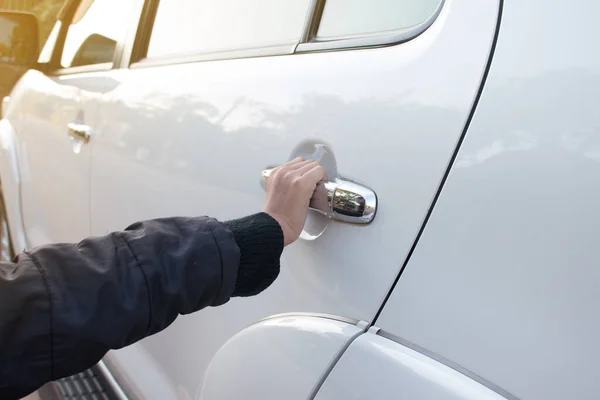 Close up of hand is opening car door.