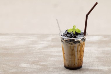 Taze sütle çimen jölesi ve plastik bardakta karamel..