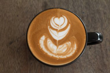 Sütten yapılmış güzel bir tabağın içindeki Latte sanatı.