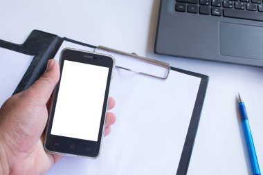 Asyalı adam ofiste çalışırken boş akıllı telefonunu tutuyor..