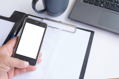 Asyalı adam ofiste çalışırken boş akıllı telefonunu tutuyor..