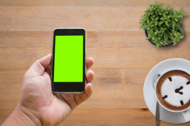 Akıllı telefon, kahve ve kaktüs ofis masası konseptiyle en iyi masa manzarası. .