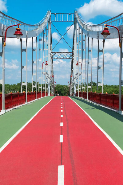 Red bike path on the bridge over the river