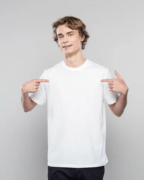 Leende Ung Man Klädd Vit Shirt Pekar Hans Bröst Med — Stockfoto