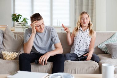 Brother and sister spending time together at home, having an argument.  clipart