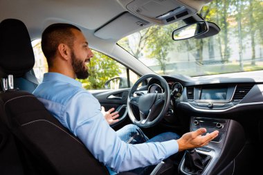 Mutlu ve genç işadamı sürücüsüz arabayı yan görünüm.