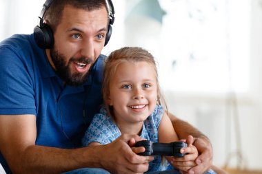Genç video oyunları oynarken kanepe ve oturma odasında ve having fun kızıyla birlikte, baba.. 