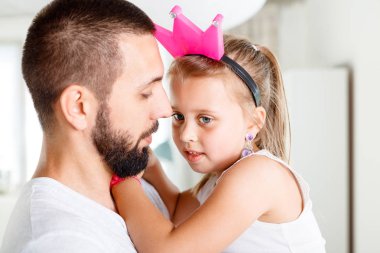 Ciddi ve endişeli genç baba kızıyla birlikte tartışmayı konuşuyor. Yüzler yakın çekim.