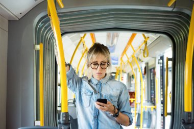 Genç kadın manifatura şehir tren cep telefonunuzda.
