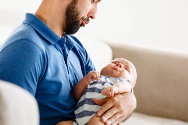 Kanepeye, ağlayan çocuk oturup onun erkek bebek, tutan genç baba.